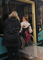 Einstig einer Rollstuhlfahrerin in eine Straßenbahn mit Hilfe eines Gabelstaplers.