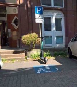 E-Scooter steht auf einem Behindertenparkplatz